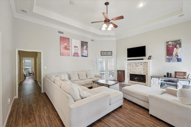 211 Skylark Ave, Bridge City, TX 77611 - living room with a tray ceiling, ceiling fan, dark wood-style flooring, crown molding, and a tile fireplace
