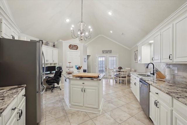 211 Skylark Ave, Bridge City, TX 77611 - kitchen featuring stainless steel appliances, a sink, vaulted ceiling, a chandelier, and white cabinets
