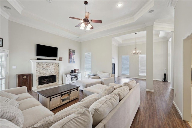 211 Skylark Ave, Bridge City, TX 77611 - living area featuring a raised ceiling, a ceiling fan, a tiled fireplace, a chandelier, and dark wood-style floors