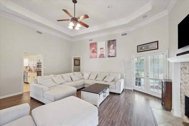 211 Skylark Ave, Bridge City, TX 77611 - living area featuring a high ceiling, wood finished floors, a ceiling fan, crown molding, and a tray ceiling