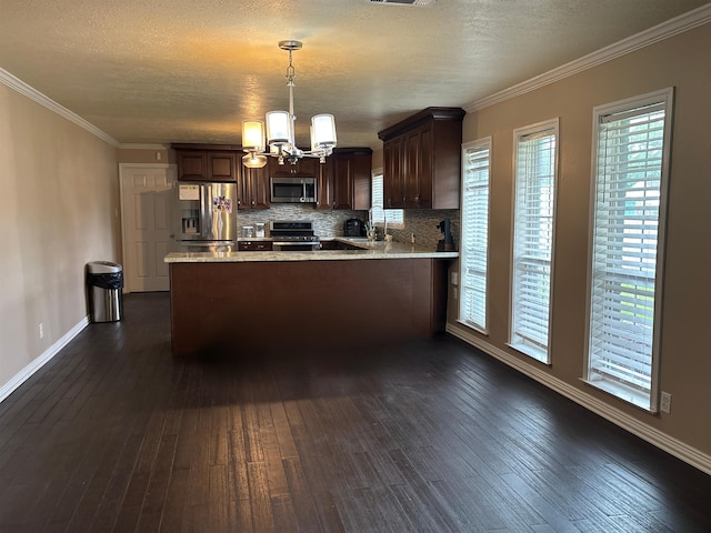 4400 Bethany St, Port Arthur, TX 77642 - kitchen with stainless steel appliances, a chandelier, dark brown cabinetry, a peninsula, and decorative backsplash