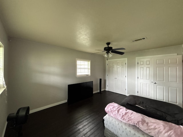 4400 Bethany St, Port Arthur, TX 77642 - bedroom with baseboards, dark wood-style flooring, two closets, and ceiling fan