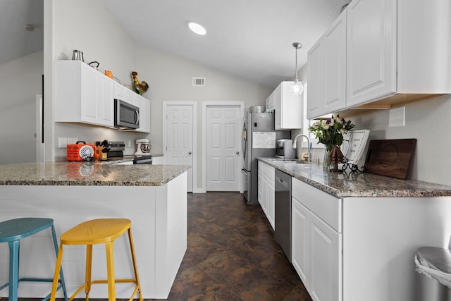 3329 Model Dr, Kountze, TX 77625 - kitchen featuring stainless steel appliances, a sink, lofted ceiling, white cabinets, and dark stone countertops