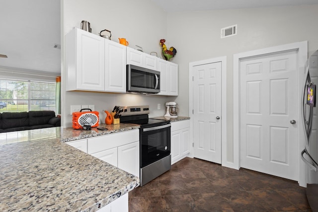 3329 Model Dr, Kountze, TX 77625 - kitchen with appliances with stainless steel finishes, white cabinetry, light stone counters, and a peninsula