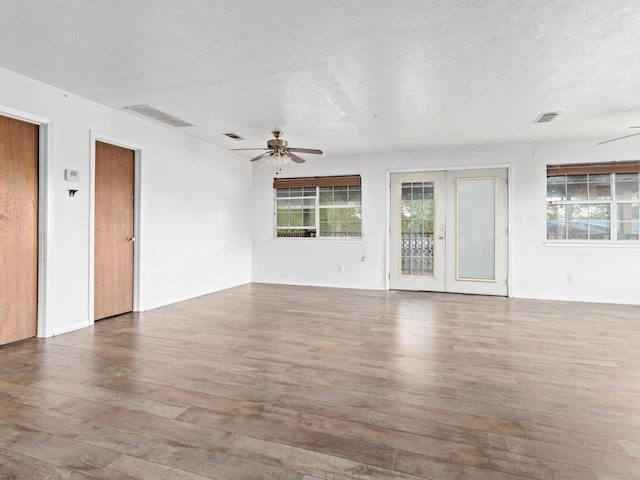 unfurnished room with hardwood / wood-style floors, ceiling fan, a textured ceiling, and french doors