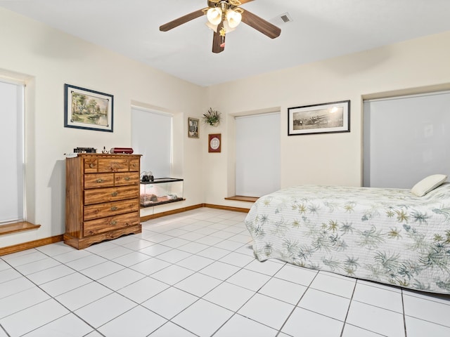 tiled bedroom featuring ceiling fan