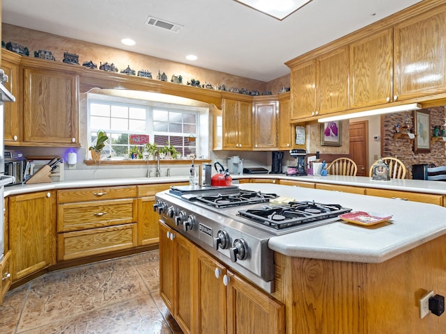 kitchen featuring kitchen peninsula, stainless steel gas stovetop, and sink