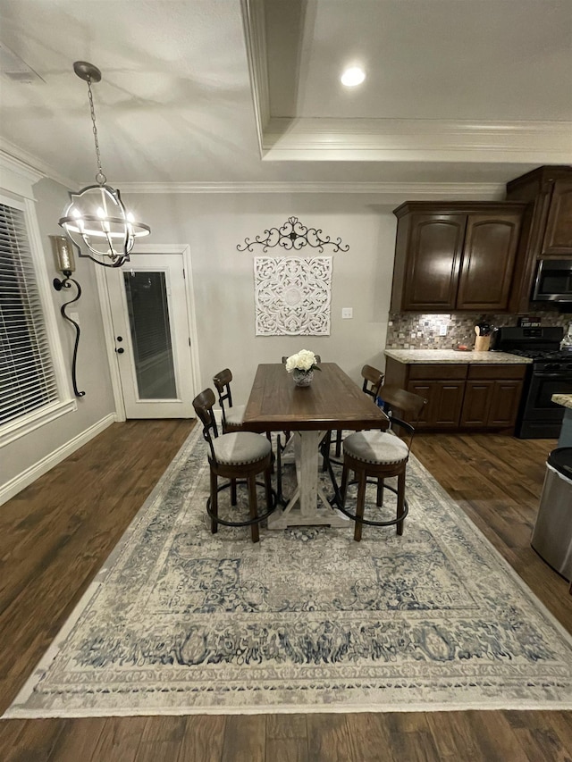 dining room featuring ornamental molding, dark hardwood / wood-style floors, and a tray ceiling