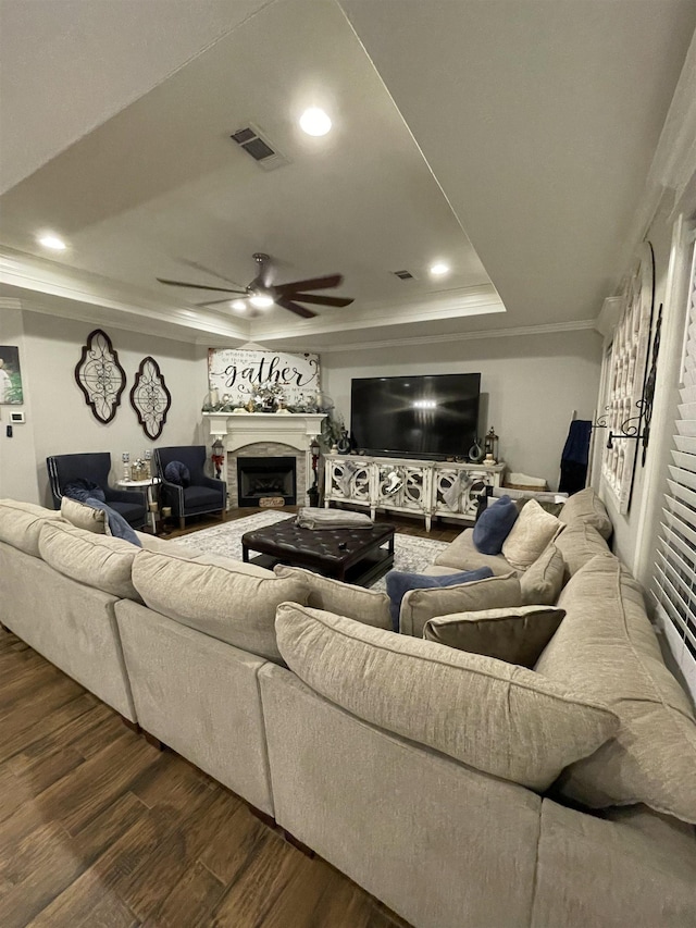 living room featuring crown molding, ceiling fan, dark hardwood / wood-style floors, and a raised ceiling