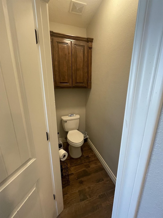 bathroom featuring hardwood / wood-style flooring and toilet