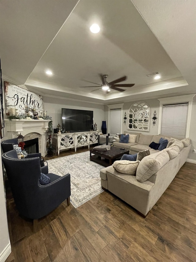 living room with hardwood / wood-style floors, ceiling fan, and a tray ceiling