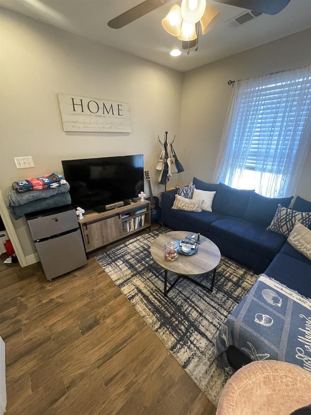 living room featuring dark wood-type flooring and ceiling fan