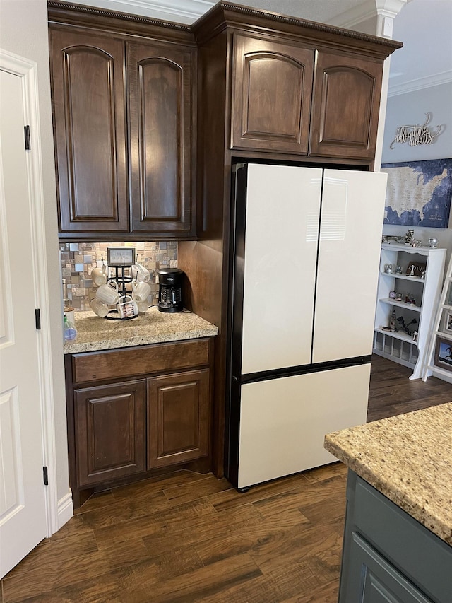 kitchen featuring dark brown cabinetry, dark wood-type flooring, and white fridge