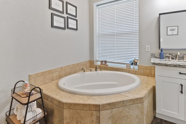 bathroom with tiled bath and vanity