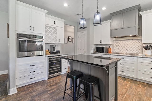 kitchen featuring white cabinets, premium range hood, wine cooler, and stainless steel oven