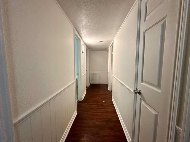 790 Pinchback Rd, Beaumont, TX 77707 - hall featuring a textured ceiling, dark wood-type flooring, and a decorative wall