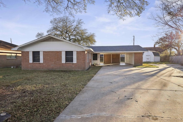 ranch-style house featuring brick siding, a storage unit, an outdoor structure, driveway, and a front lawn