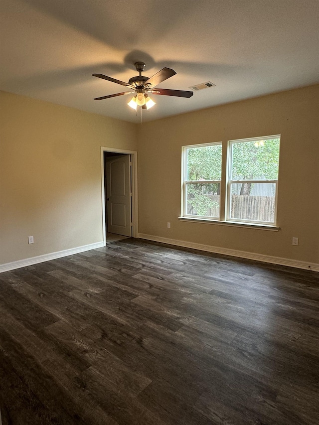 unfurnished room with ceiling fan and dark wood-type flooring