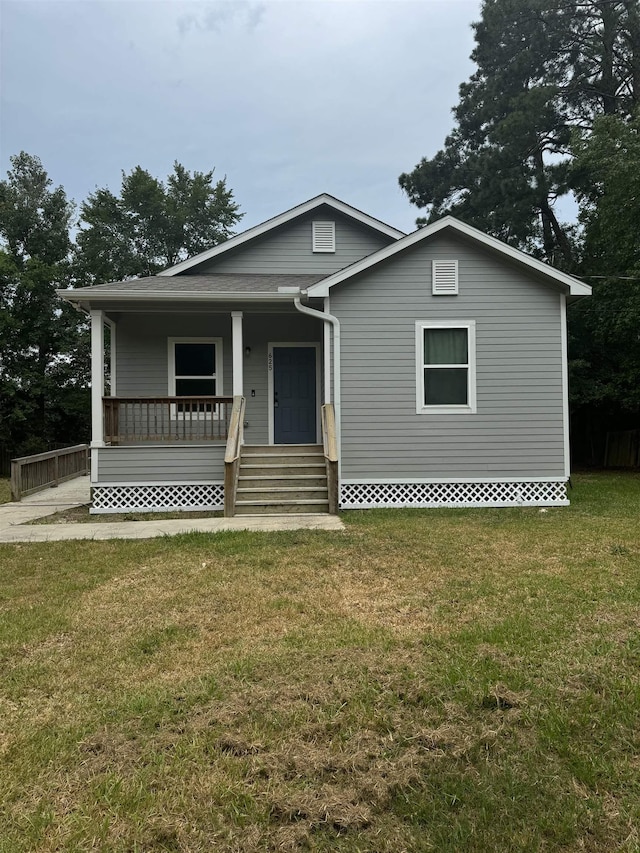 view of front of house featuring covered porch and a front yard