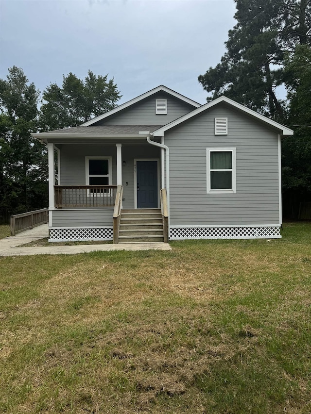 view of front facade featuring covered porch and a front yard