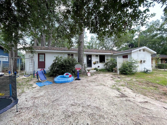 rear view of house featuring cooling unit and a trampoline