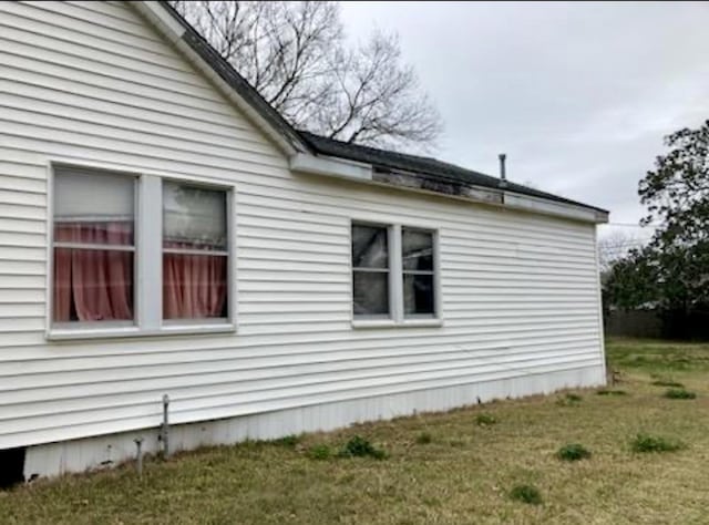 view of side of home with a lawn