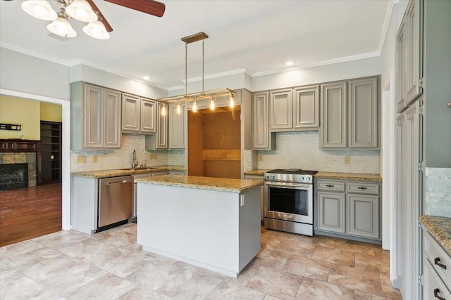 kitchen featuring pendant lighting, sink, a center island, stainless steel appliances, and crown molding