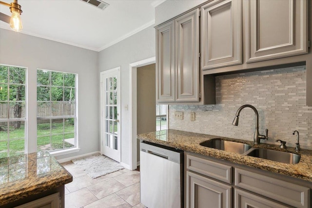 kitchen with dishwasher, sink, crown molding, and dark stone counters