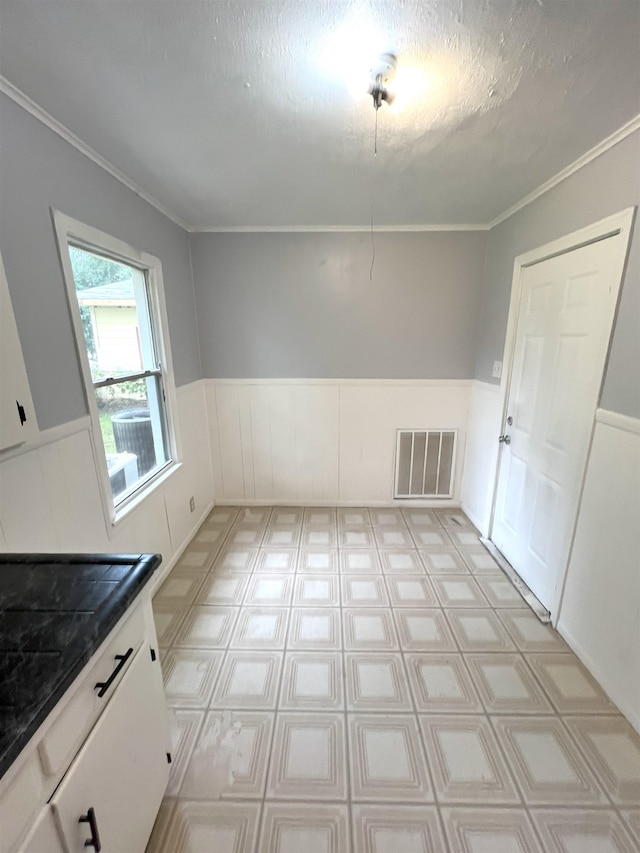 unfurnished dining area with a textured ceiling