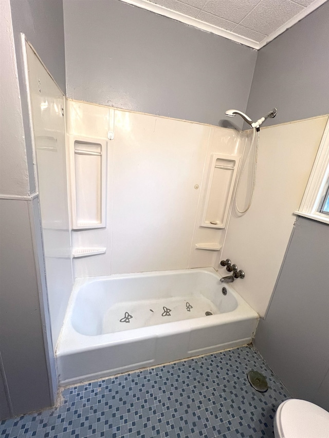 bathroom with a textured ceiling,  shower combination, and toilet