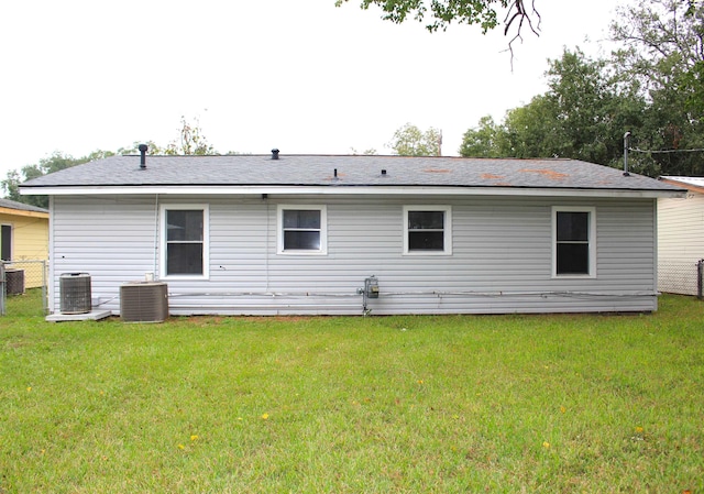 back of property featuring a yard and central AC