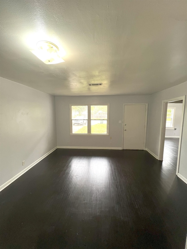 empty room with dark wood-type flooring