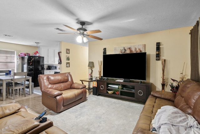 tiled living room featuring ceiling fan and a textured ceiling