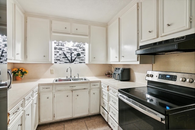 kitchen with stainless steel electric stove, white cabinets, light tile patterned floors, and sink