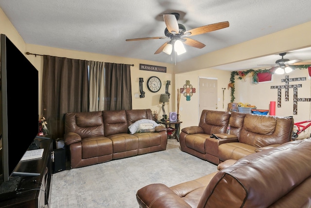 carpeted living room featuring a textured ceiling and ceiling fan