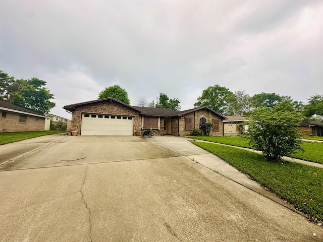 single story home with an attached garage, stone siding, driveway, a front lawn, and brick siding