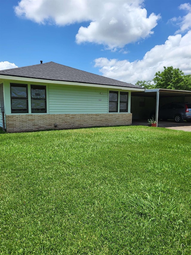 view of front of property with a carport and a front lawn