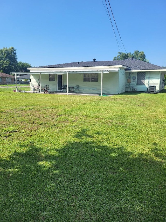 back of house featuring central air condition unit, a patio area, and a yard