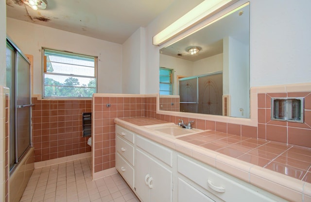 full bathroom with vanity, tile walls, enclosed tub / shower combo, tile patterned flooring, and toilet