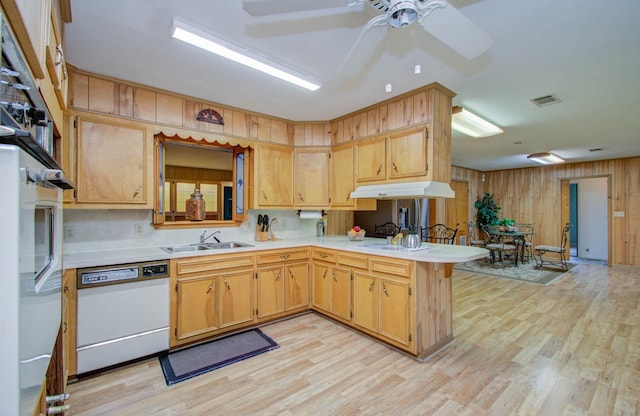 kitchen featuring kitchen peninsula, light wood-type flooring, ceiling fan, sink, and dishwasher