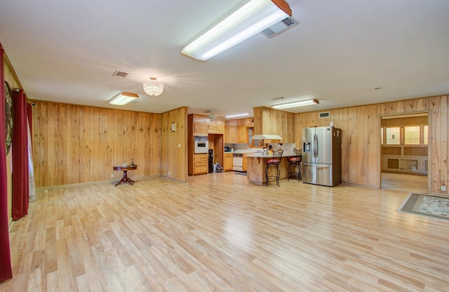 living room featuring wooden walls and light hardwood / wood-style flooring