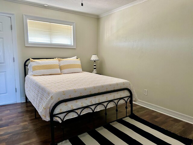 560 Pleasure Island Blvd, Port Arthur, TX 77640 - bedroom featuring dark wood-style flooring, crown molding, and baseboards