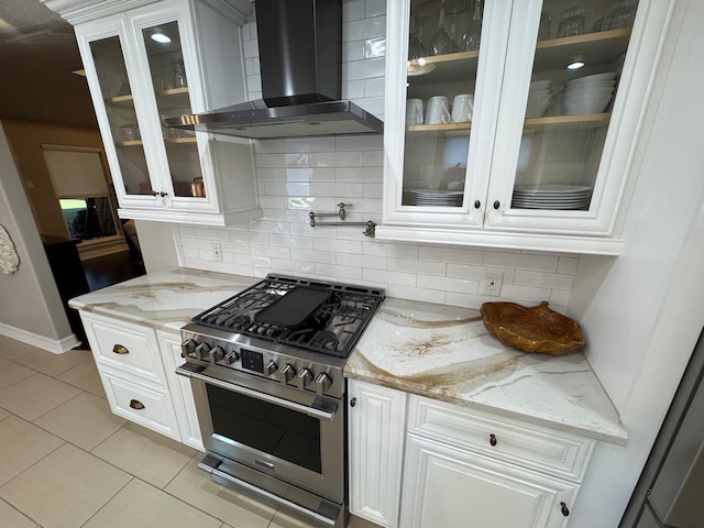 kitchen featuring white cabinets, light stone countertops, high end stainless steel range, and wall chimney range hood