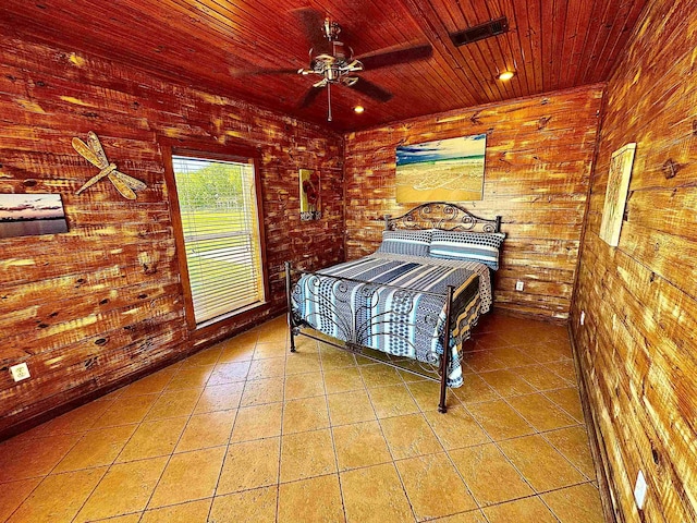 bedroom with wood ceiling, ceiling fan, visible vents, tile patterned flooring, and wooden walls