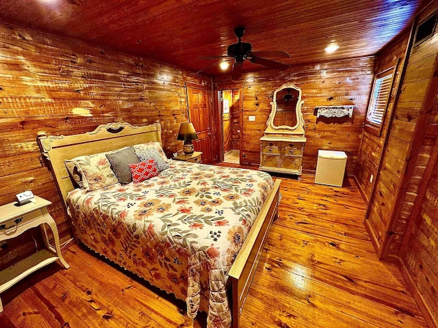 bedroom featuring wooden walls, wood ceiling, and hardwood / wood-style flooring