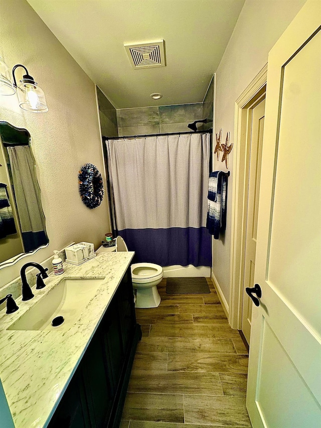full bathroom featuring visible vents, wood finished floors, toilet, and vanity