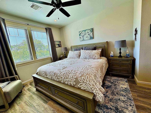 bedroom with baseboards, visible vents, and wood finished floors