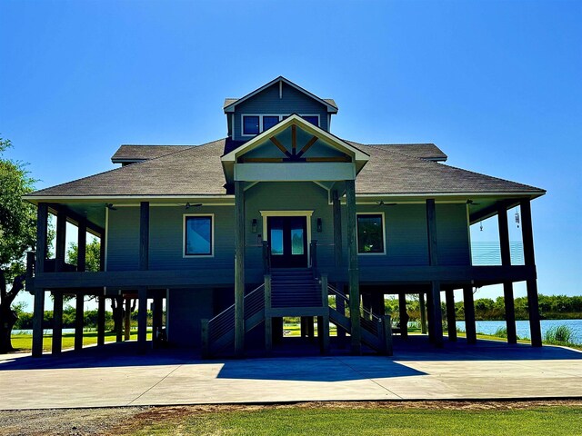 view of front of home featuring roof with shingles, driveway, stairway, and a carport