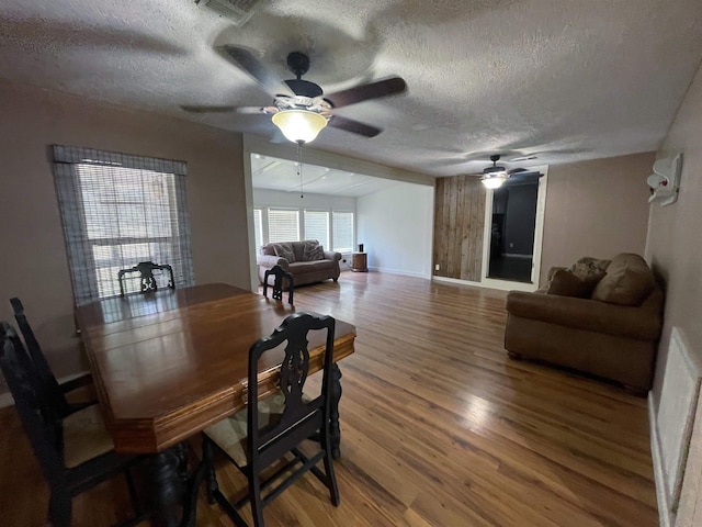 dining room with hardwood / wood-style flooring, ceiling fan, and a textured ceiling