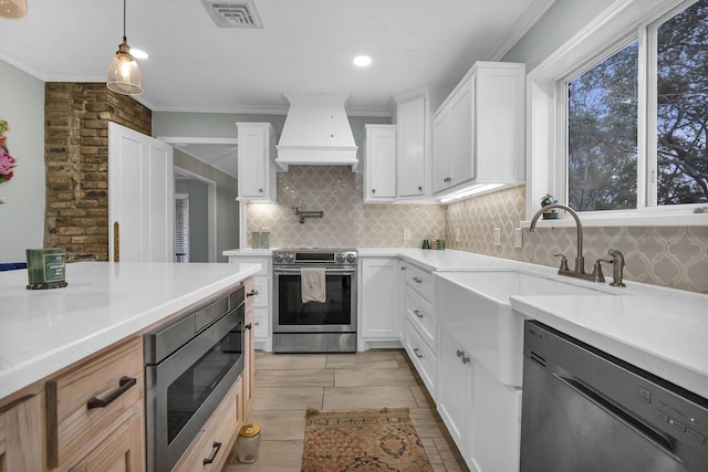 5855 Gladys Ave, Beaumont, TX 77706 - kitchen with stainless steel appliances, custom exhaust hood, light countertops, crown molding, and decorative backsplash